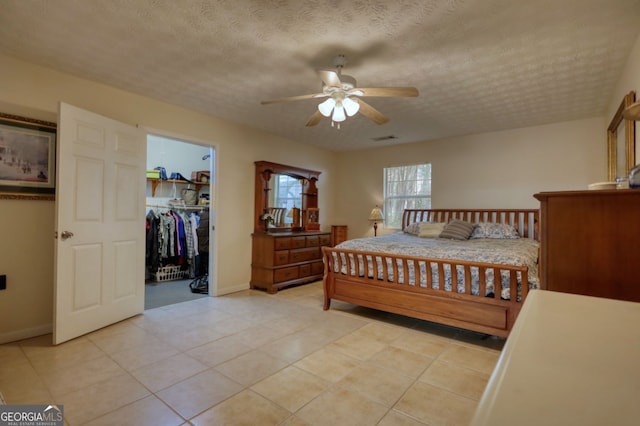 bedroom with a spacious closet, visible vents, a closet, and a textured ceiling