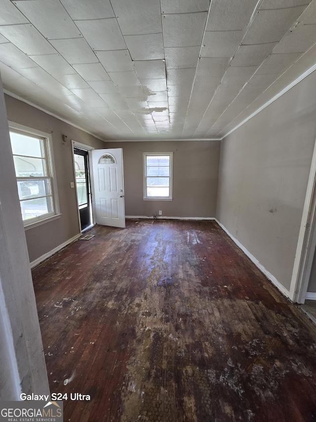 interior space featuring hardwood / wood-style flooring, baseboards, and crown molding
