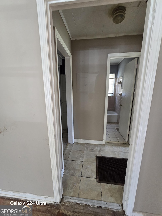 hallway featuring tile patterned floors and ornamental molding