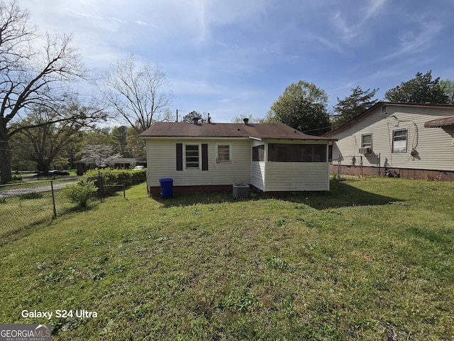 back of house featuring a sunroom, fence, central AC unit, cooling unit, and a yard