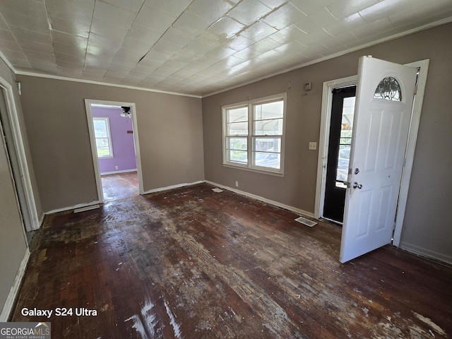 foyer with a wealth of natural light, visible vents, crown molding, and wood-type flooring