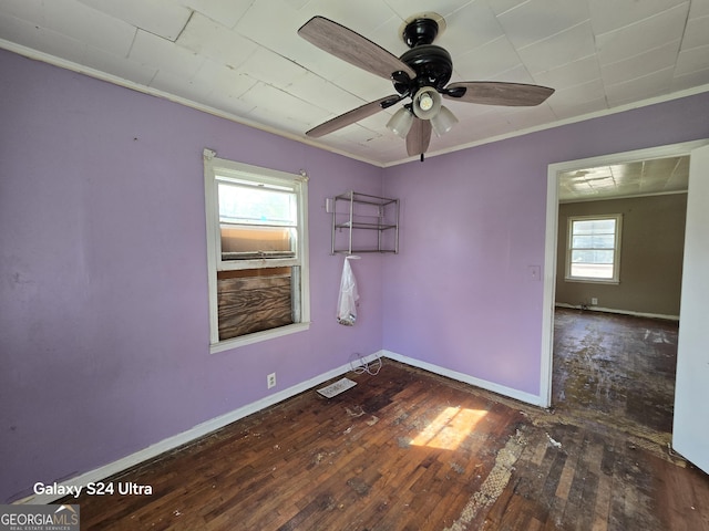 empty room featuring baseboards, crown molding, a ceiling fan, and wood-type flooring