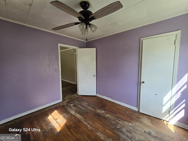 spare room featuring crown molding, hardwood / wood-style flooring, baseboards, and ceiling fan