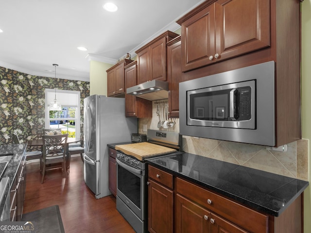 717 Bay Skipper Ct, Griffin, GA 30223 - kitchen with stainless steel appliances, under cabinet range hood, ornamental molding, dark wood finished floors, and tasteful backsplash