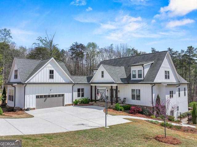 modern farmhouse style home featuring a garage, a front yard, board and batten siding, driveway, and a shingled roof