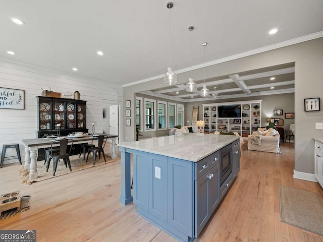 kitchen with coffered ceiling, light stone counters, open floor plan, light wood-style flooring, and built in microwave