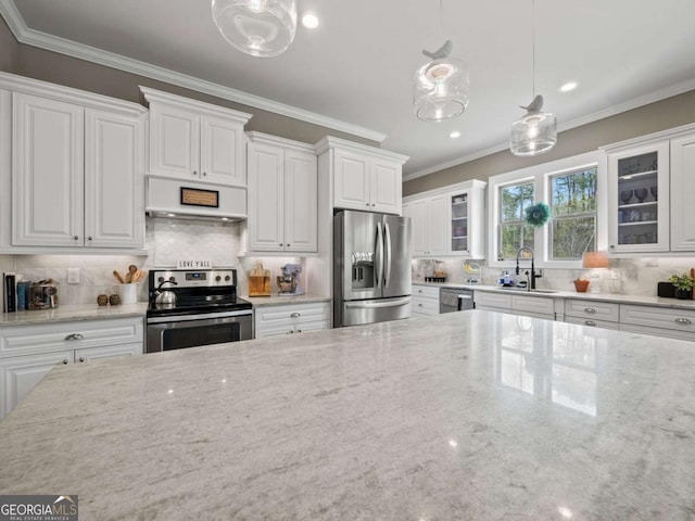 kitchen with glass insert cabinets, a sink, premium range hood, and appliances with stainless steel finishes