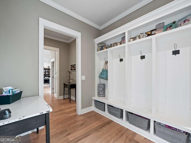 mudroom with baseboards, crown molding, and wood finished floors
