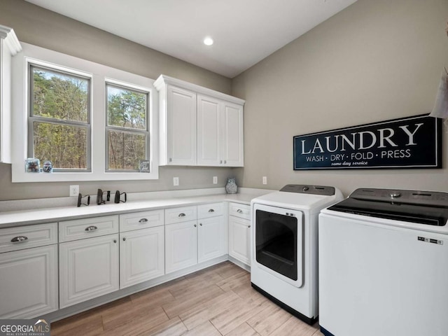 laundry area with washer and dryer, light wood-style flooring, cabinet space, and recessed lighting