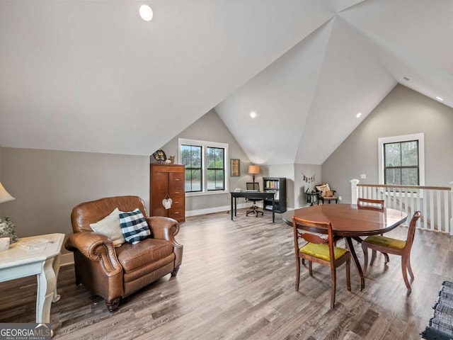 dining room with baseboards, lofted ceiling, and wood finished floors