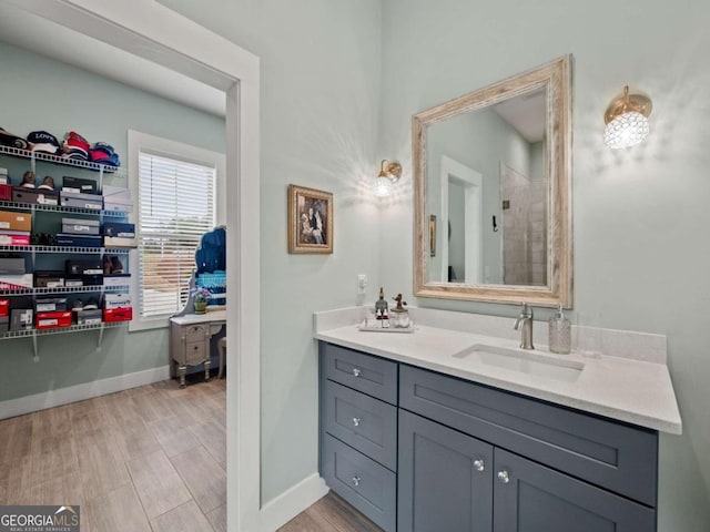 bathroom featuring baseboards, wood finished floors, and vanity