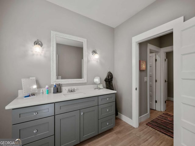 bathroom featuring vanity, baseboards, and wood finished floors