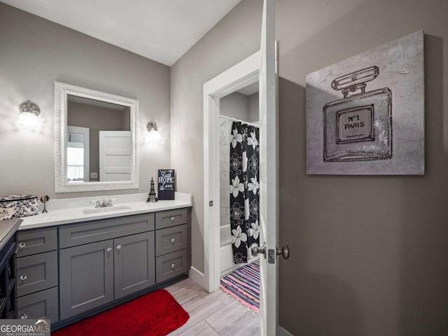 bathroom with shower / bath combination with curtain, wood finished floors, and vanity
