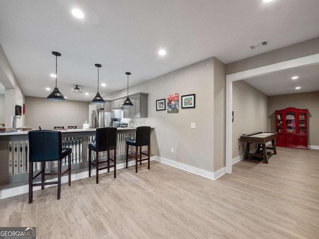 interior space with freestanding refrigerator, baseboards, light wood-style floors, and visible vents
