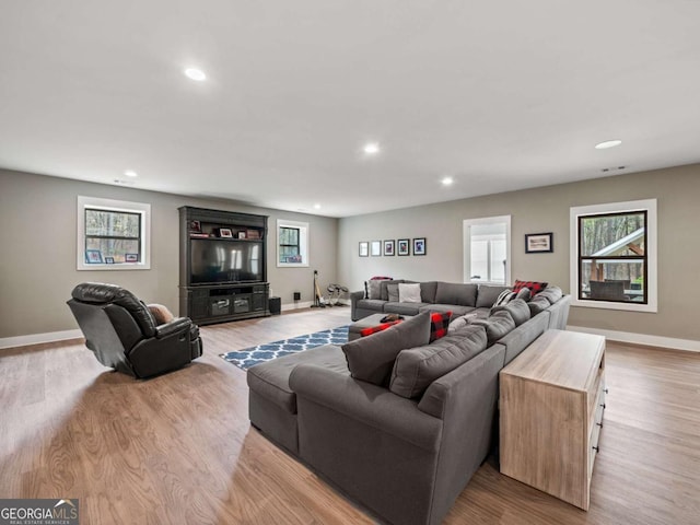 living room with baseboards, visible vents, recessed lighting, and light wood finished floors