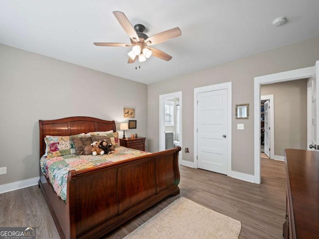 bedroom featuring baseboards, wood finished floors, and ceiling fan