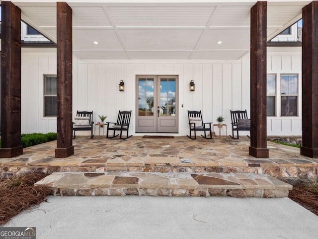 property entrance featuring french doors, board and batten siding, and a patio area