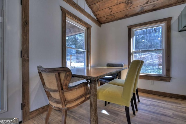 dining room featuring baseboards, wooden ceiling, and a healthy amount of sunlight