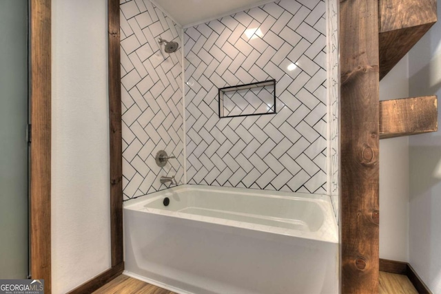 bathroom with baseboards, shower / tub combination, and wood finished floors