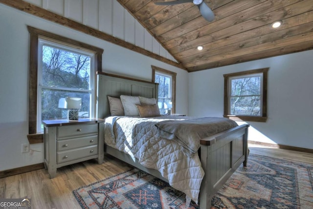 bedroom featuring baseboards, light wood-style floors, vaulted ceiling, and wood ceiling