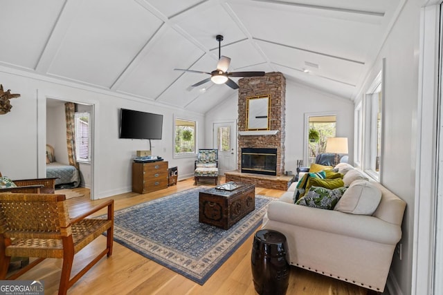 living area featuring ceiling fan, light wood-type flooring, and vaulted ceiling