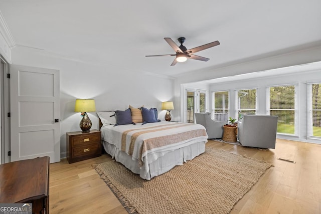 sunroom featuring crown molding and wood finished floors