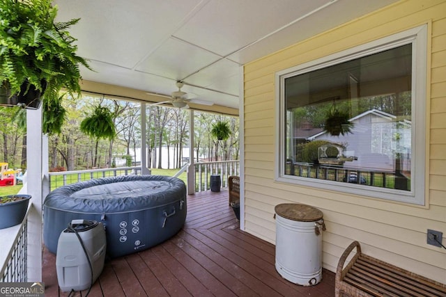 wooden terrace with a lawn, outdoor dining space, and ceiling fan
