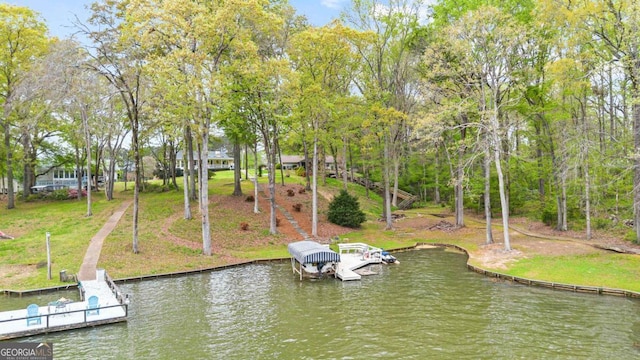dock area with a water view, a yard, and boat lift