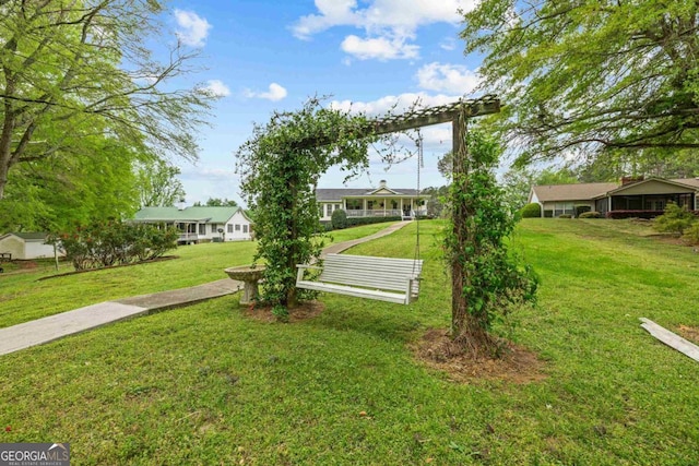 view of front of property with an outbuilding, a front yard, a garage, asphalt driveway, and view of scattered trees