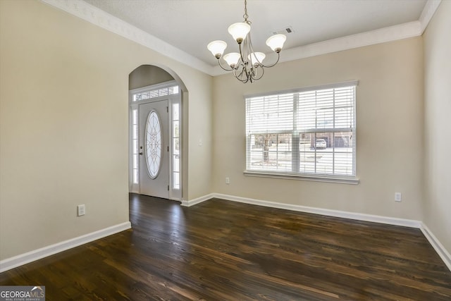 6793 Oconee Pl, Fairburn, GA 30213 - entryway with arched walkways, a chandelier, dark wood-type flooring, and ornamental molding