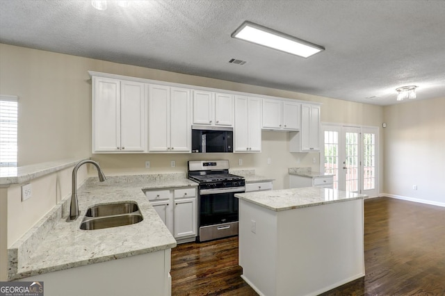 6793 Oconee Pl, Fairburn, GA 30213 - kitchen with appliances with stainless steel finishes, a textured ceiling, white cabinets, dark wood-type flooring, and light stone countertops