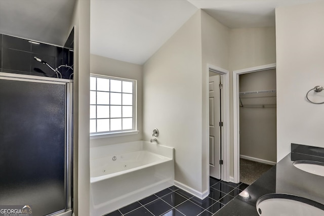 full bath featuring a shower stall, tile patterned flooring, a jetted tub, and a walk in closet