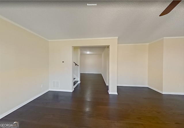 spare room featuring a ceiling fan, baseboards, dark wood finished floors, and crown molding