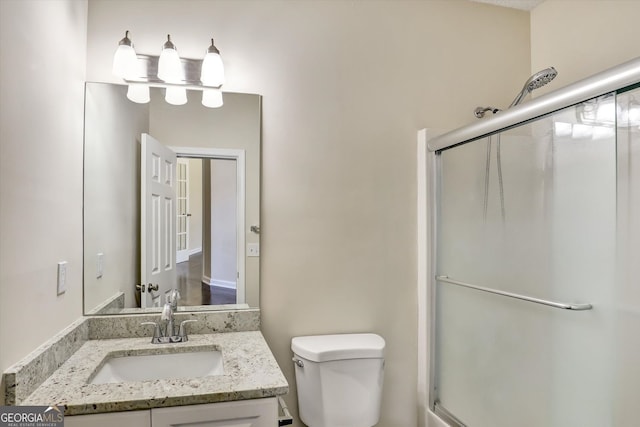full bath with vanity, toilet, and an enclosed shower
