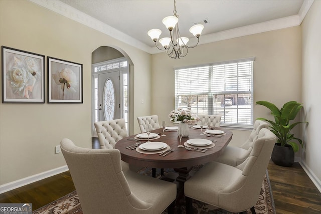 dining room featuring an inviting chandelier, plenty of natural light, baseboards, and arched walkways