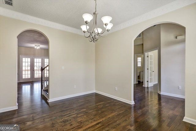 6793 Oconee Pl, Fairburn, GA 30213 - empty room featuring french doors, arched walkways, dark wood-type flooring, a textured ceiling, and ornamental molding