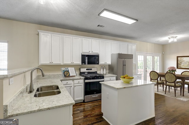 kitchen with a sink, stainless steel appliances, visible vents, and white cabinets