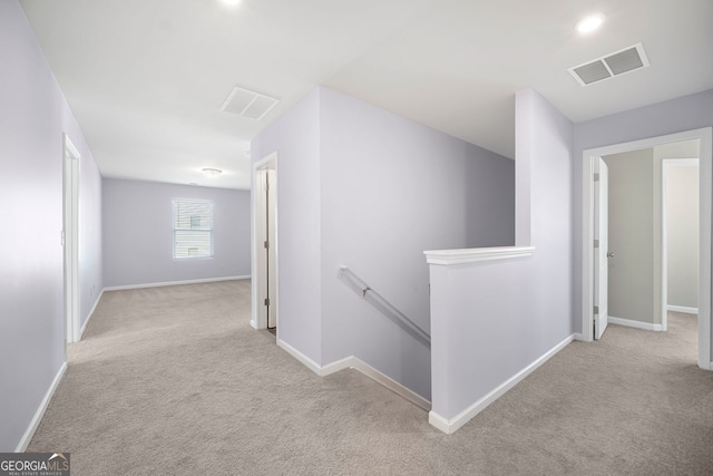 corridor featuring visible vents, baseboards, an upstairs landing, and carpet