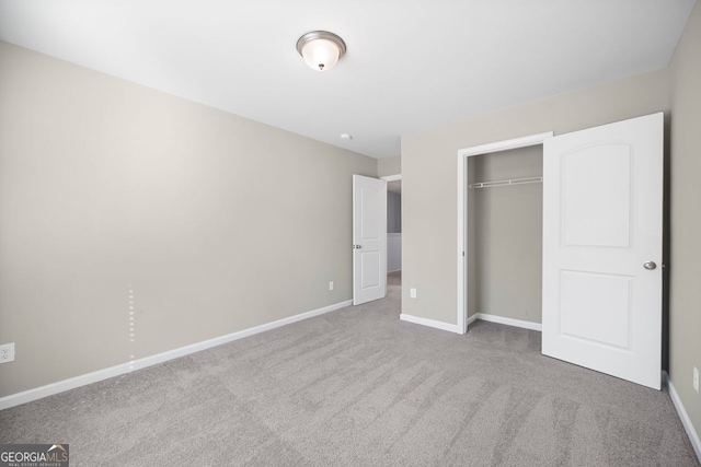 unfurnished bedroom featuring a closet, carpet flooring, and baseboards