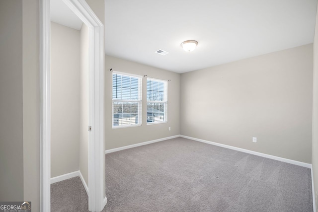 carpeted spare room with baseboards and visible vents