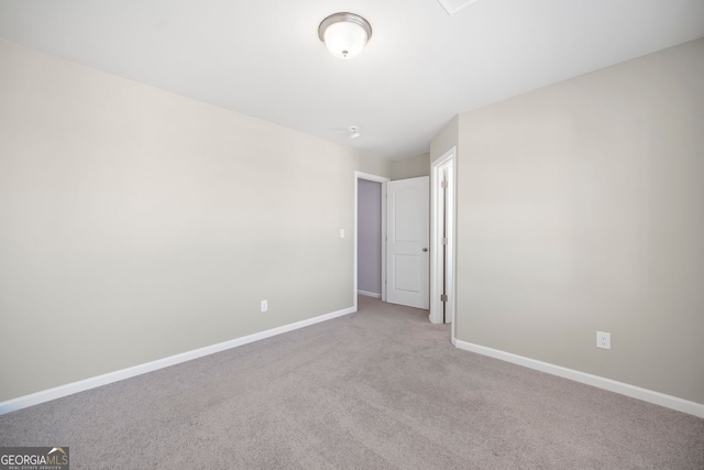 carpeted empty room featuring baseboards