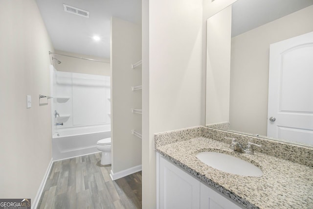 full bath featuring visible vents, toilet, shower / bath combination, vanity, and wood finished floors