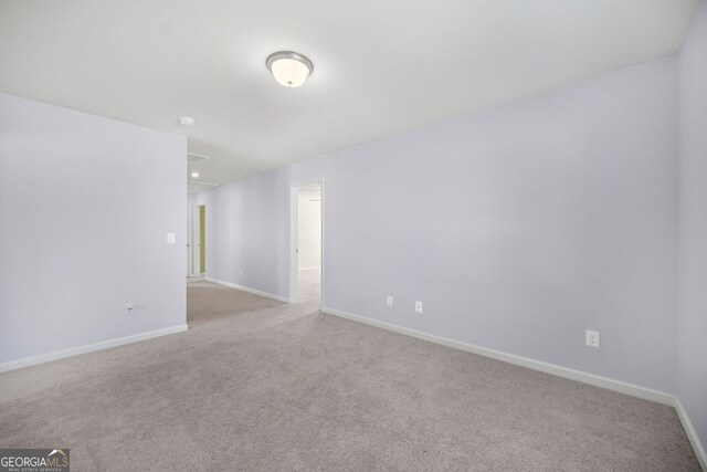unfurnished room with carpet flooring and baseboards