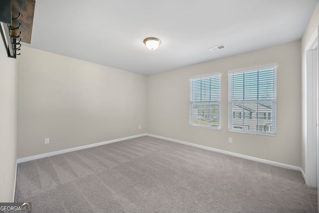 carpeted empty room with baseboards and visible vents