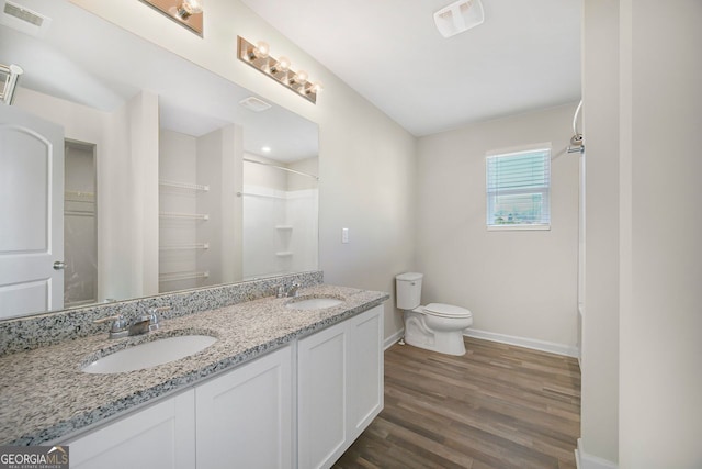bathroom with visible vents, baseboards, a sink, toilet, and a shower