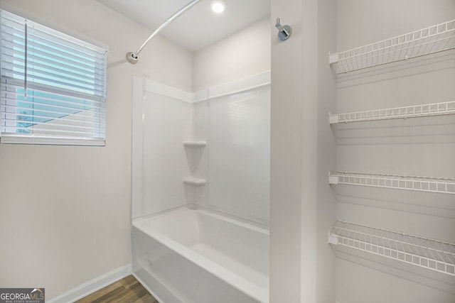 bathroom featuring washtub / shower combination, baseboards, recessed lighting, and wood finished floors