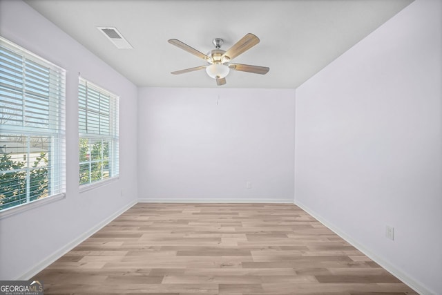 unfurnished room with light wood-style floors, baseboards, a ceiling fan, and visible vents