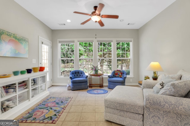 living area featuring light tile patterned floors, baseboards, ceiling fan, and visible vents