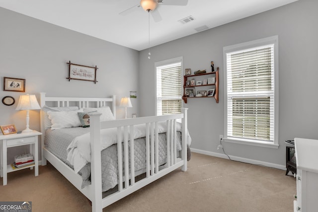 carpeted bedroom featuring visible vents, a ceiling fan, and baseboards