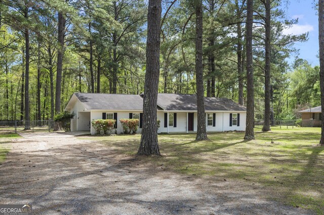 single story home featuring fence, dirt driveway, and an attached carport